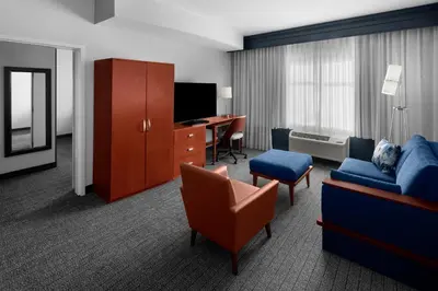 a hotel room with a couch chair and a desk at Courtyard by Marriott Santa Clarita Valencia in Valencia