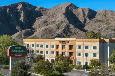 a hotel building with mountains in the background at Courtyard by Marriott Santa Clarita Valencia in Valencia