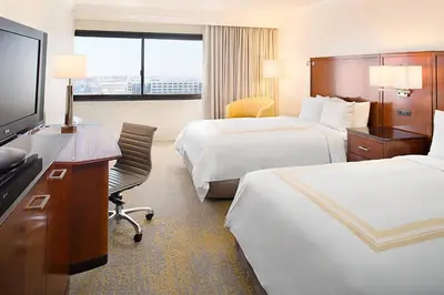 a hotel room with two beds and a flat screen tv at Los Angeles Marriott Burbank Airport in Burbank