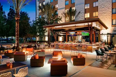 a hotel patio with tables and chairs and a restaurant at Los Angeles Marriott Burbank Airport in Burbank