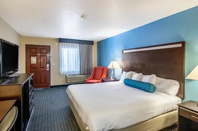 a hotel room with a large bed and a television at Glenridge Inn Glendale - Pasadena in Glendale