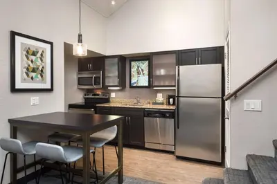a kitchen with a stainless steel refrigerator and a table at Residence Inn by Marriott Long Beach in Long Beach