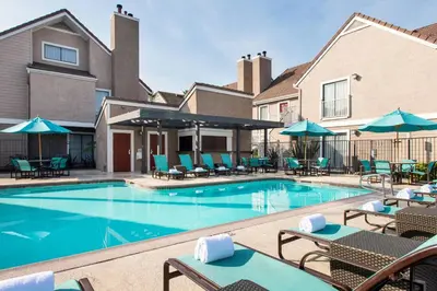 a pool at a hotel with chairs and umbrellas at Residence Inn by Marriott Long Beach in Long Beach