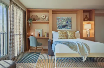 a bedroom with a bed and a chair and a window at Viceroy Santa Monica in Los Angeles