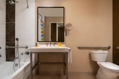 a bathroom with a sink and a toilet and a mirror at JW Marriott Los Angeles L.A. LIVE in Los Angeles