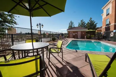 a patio with a table and chairs and a pool at SpringHill Suites Ridgecrest in Ridgecrest