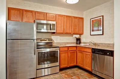 a kitchen with wooden cabinets and stainless steel appliances at Residence Inn Los Angeles LAX/El Segundo in El Segundo