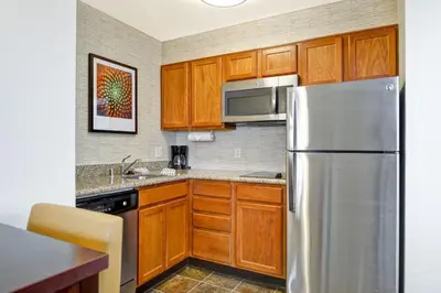 a kitchen with wooden cabinets and a stainless steel refrigerator at Residence Inn Los Angeles LAX/El Segundo in El Segundo