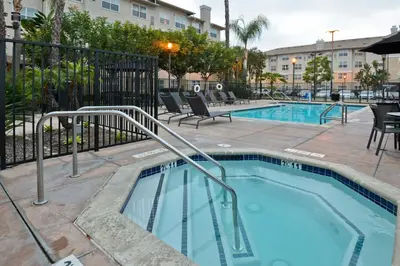 a swimming pool with chairs next to a building at Residence Inn Los Angeles LAX/El Segundo in El Segundo