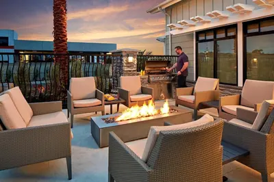 a man standing on a patio with a fire pit at Residence Inn Los Angeles LAX/Manhattan Beach in Manhattan Beach