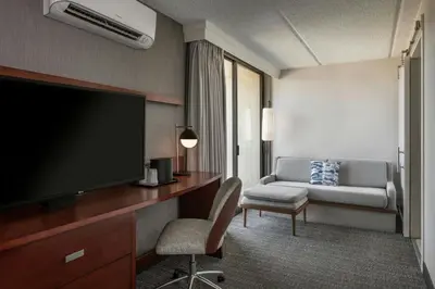 a hotel room with a flat screen tv and a couch at Courtyard by Marriott Los Angeles Pasadena/Monrovia in Monrovia