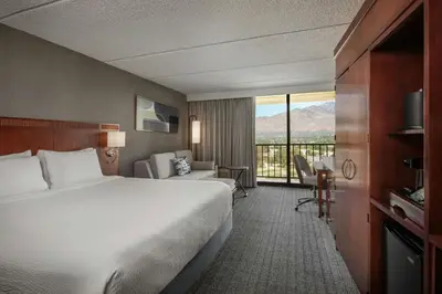 a hotel room with a bed and a balcony at Courtyard by Marriott Los Angeles Pasadena/Monrovia in Monrovia