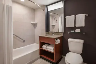 a bathroom with a toilet and a sink and a tub at Courtyard by Marriott Los Angeles Pasadena/Monrovia in Monrovia