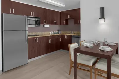 a kitchen with a table and a white refrigerator at Residence Inn by Marriott Santa Clarita Valencia in Santa Clarita