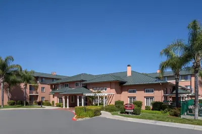 a large apartment building with palm trees and a street at Residence Inn by Marriott Santa Clarita Valencia in Santa Clarita