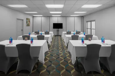 a conference room with tables and chairs and a screen at Fairfield Inn by Marriott Santa Clarita Valencia in Santa Clarita