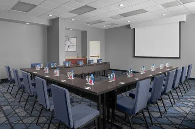 a long table in a room with chairs and a screen at Courtyard by Marriott Cypress Anaheim / Orange County in Cypress