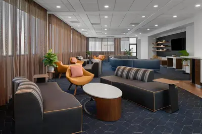 a waiting room with couches and tables and chairs at Courtyard by Marriott Cypress Anaheim / Orange County in Cypress