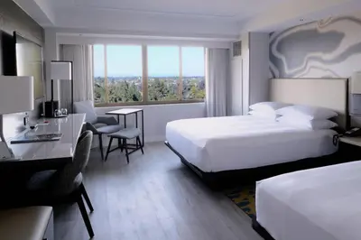 a hotel room with two beds and a desk and a desk at Long Beach Marriott in Long Beach