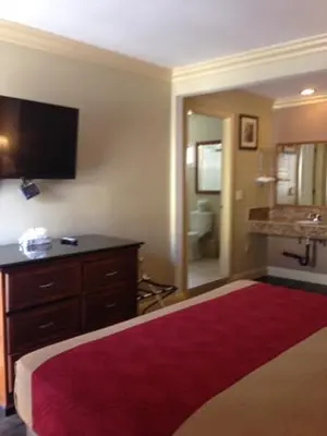 a hotel room with a large bed and a bathroom at Pacifica Motel in Long Beach