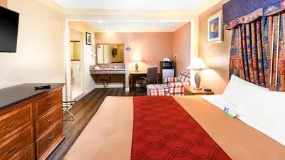 a hotel room with a bed and a desk at Pacifica Motel in Long Beach