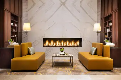 a lobby with two yellow chairs and a fireplace at Sheraton Los Angeles San Gabriel in San Gabriel