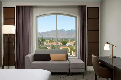 a living room with a couch and a large window at Sheraton Los Angeles San Gabriel in San Gabriel