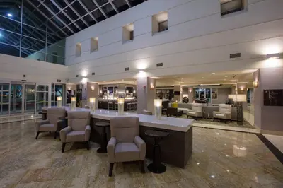 a large lobby with a bar with chairs and tables at Bakersfield Marriott at the Convention Center in Bakersfield