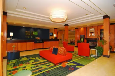 a lobby with red chairs and a living room at Fairfield Inn & Suites Tehachapi in Tehachapi