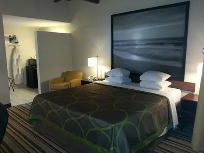 a hotel room with a bed with a large painting on the wall at Super 8 by Wyndham Los Angeles-Culver City Area in Los Angeles