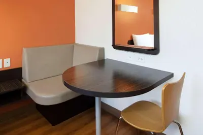 a table and chair in a room with a mirror at Motel 6-Arcadia, CA - Los Angeles - Pasadena Area in Arcadia