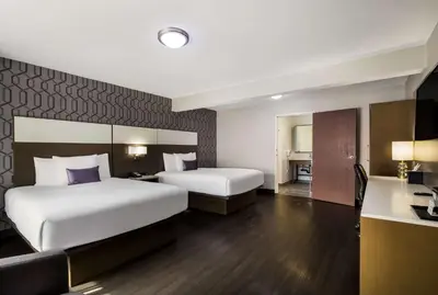 a hotel room with two beds and a kitchen at Sunset West Hotel, SureStay Collection By Best Western in Los Angeles