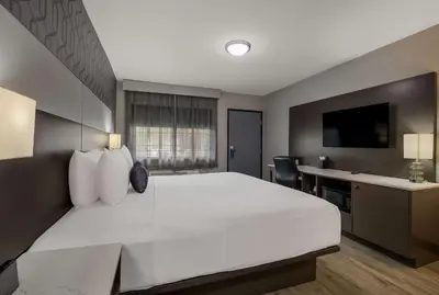 a hotel room with a large white bed and a desk at Sunset West Hotel, SureStay Collection By Best Western in Los Angeles