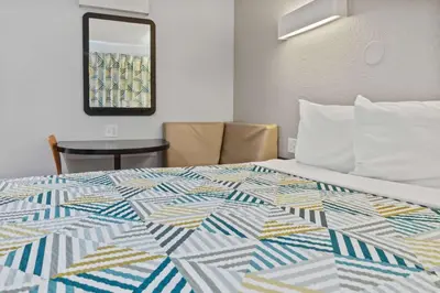 a bedroom with a bed with a colorful quilt on it at Motel 6-Ventura, CA - Beach in Ventura