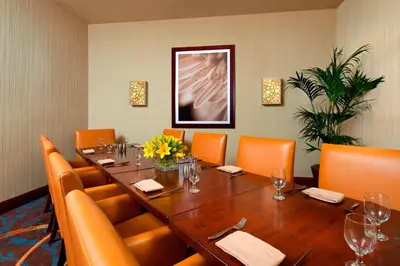 a conference room with a long table and orange chairs at Sheraton Agoura Hills Hotel in Agoura Hills