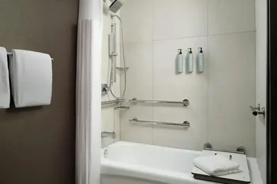 a bathroom with a tub and a sink and a shower at Courtyard by Marriott Los Angeles Pasadena Old Town in Pasadena