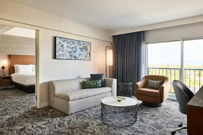 a hotel room with a couch and chair and a bed at Courtyard Los Angeles Sherman Oaks in Sherman Oaks