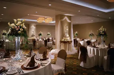 a banquet hall with white tables and chairs and flowers at Courtyard Los Angeles Sherman Oaks in Sherman Oaks