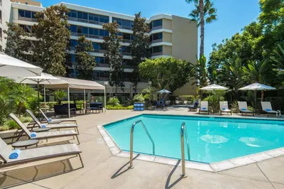 a pool at a hotel with lounge chairs and umbrellas at Fullerton Marriott at California State University in Fullerton