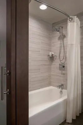 a bathroom with a bath tub with a shower at Fullerton Marriott at California State University in Fullerton