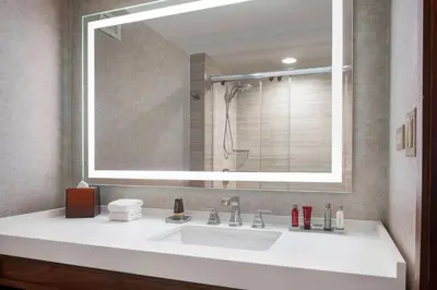 a bathroom with a sink and a large mirror at Fullerton Marriott at California State University in Fullerton