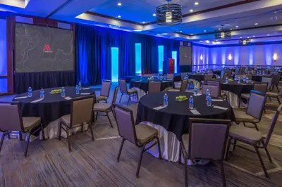 a conference room with tables and chairs and a stage at Fullerton Marriott at California State University in Fullerton