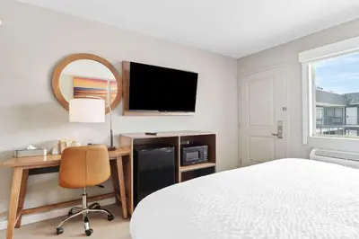 a bedroom with a bed and a desk and a tv at Clarion Pointe Ridgecrest near China Lake Naval Station in Ridgecrest