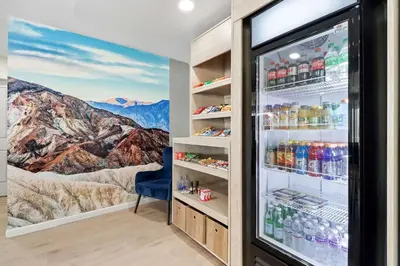 a refrigerator filled with drinks in a room with mountains at Clarion Pointe Ridgecrest near China Lake Naval Station in Ridgecrest