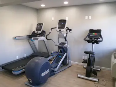 a gym with several tread machines in a room at Clarion Pointe Ridgecrest near China Lake Naval Station in Ridgecrest