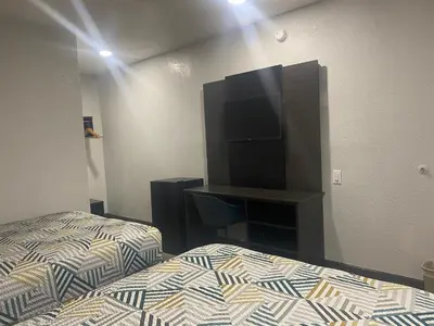 a bedroom with a bed and a flat screen tv at Motel 6-San Bernardino, CA - South in San Bernardino