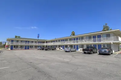 a large building with cars parked in a parking lot at Motel 6-San Bernardino, CA - South in San Bernardino