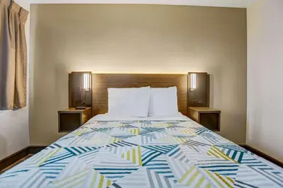 a bed in a hotel room with a colorful bedspread at Motel 6-San Bernardino, CA - South in San Bernardino
