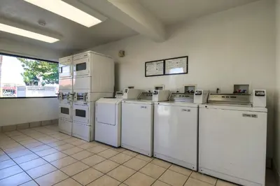 a laundry room with white appliances and a tile floor at Motel 6-Stanton, CA- Anaheim West in Stanton