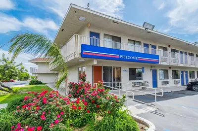 a hotel building with flowers in front of it at Motel 6-Bakersfield, CA - Airport in Bakersfield